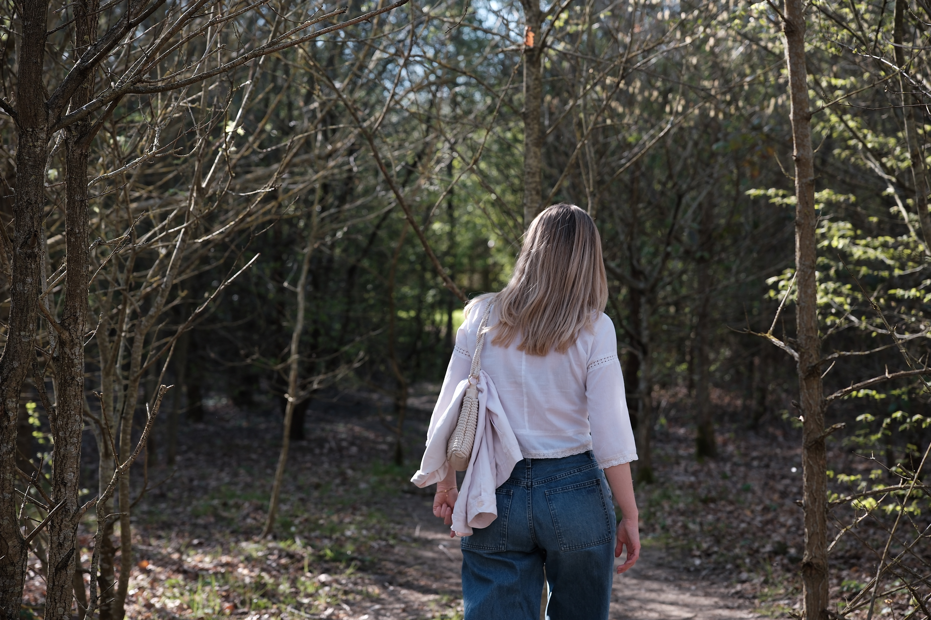 Woman walking into woodland